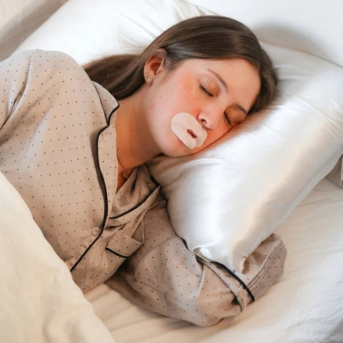 Žena během spánku používá pásky na ústa Gudslip, které zabraňují dýchání ústy a podporují přirozené nosní dýchání.