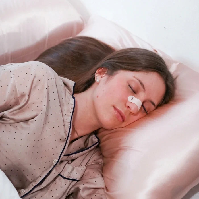 Muž spící s nosní páskou Gudslip, která přirozeně uvolňuje nosní cesty a zajišťuje volné dýchání bez chemie.